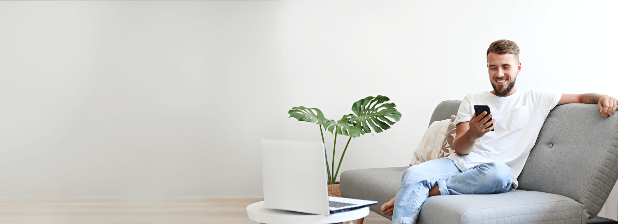 Kiemelt tartalom, A man is sitting on the couch with a mobile phone in his hand.